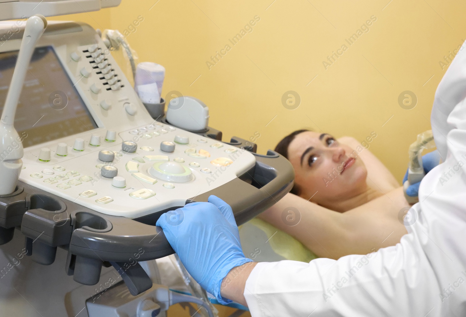 Photo of Mammologist conducting ultrasound examination of woman's breast in clinic, closeup