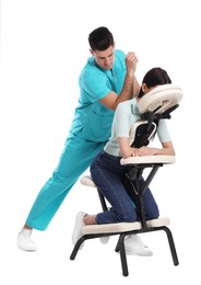 Woman receiving massage in modern chair on white background