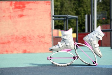 Photo of Stylish kangoo jumping boots in workout park. Space for text