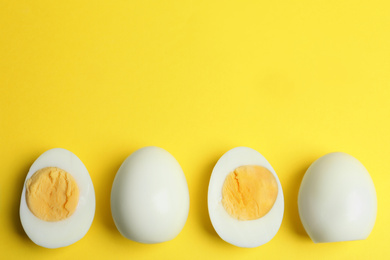 Photo of Fresh hard boiled chicken eggs on yellow background, flat lay. Space for text