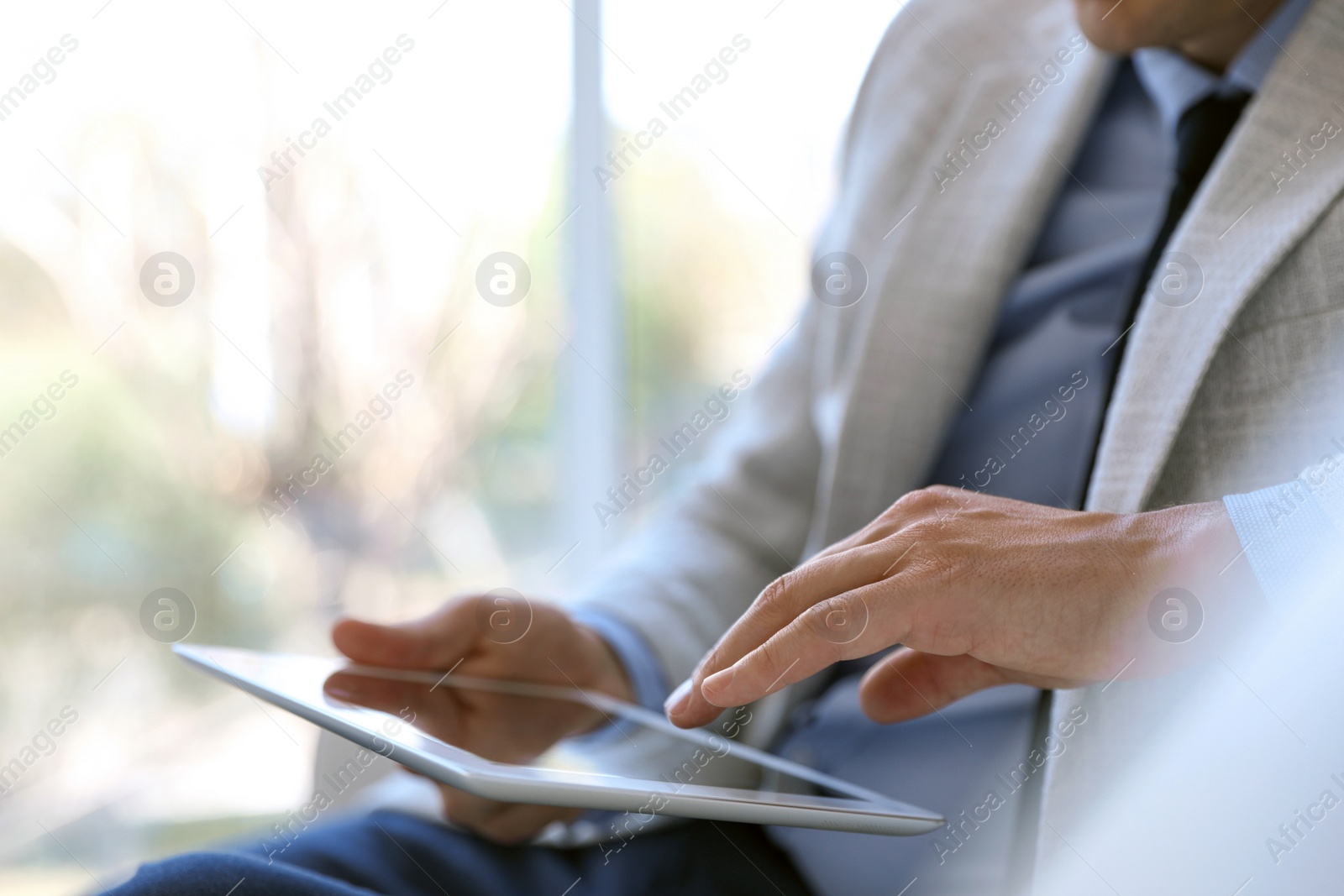 Photo of Businessman working with modern tablet in office, closeup