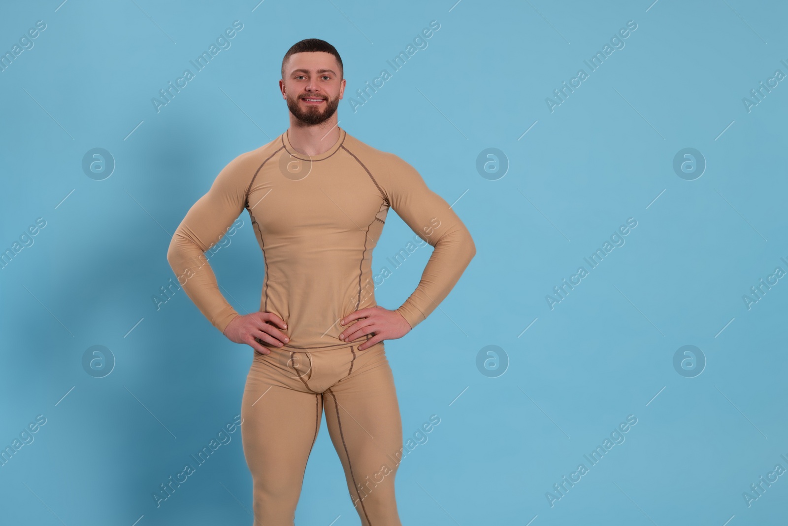 Photo of Man in warm thermal underwear on light blue background. Space for text