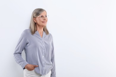 Portrait of beautiful senior woman in glasses on white background. Space for text