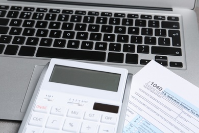 Photo of Calculator, document and laptop on table, closeup. Tax accounting