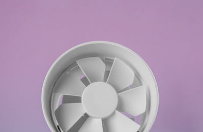 Photo of Modern electric fan on pink background, closeup