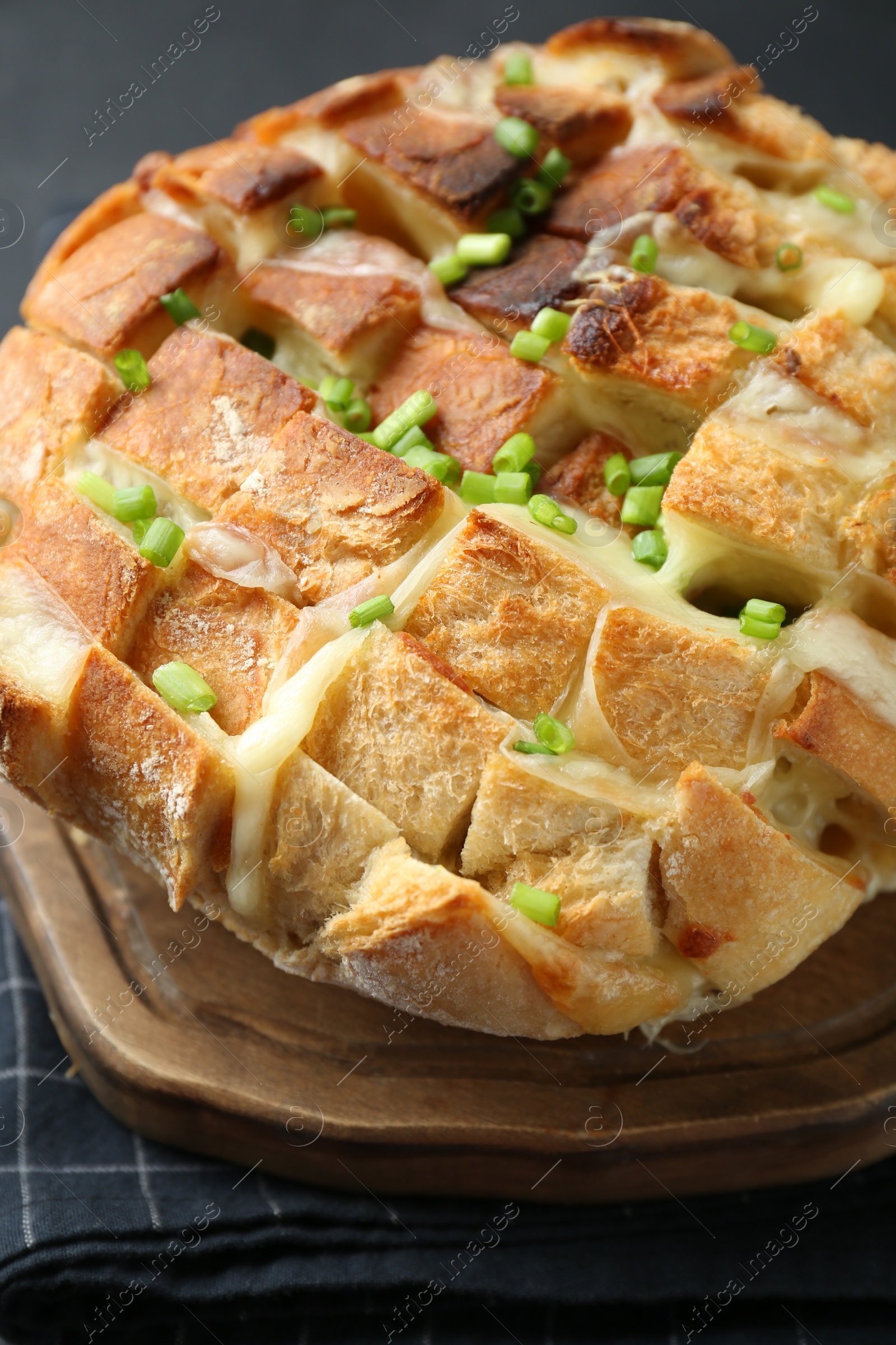 Photo of Freshly baked bread with tofu cheese and green onions on table, closeup