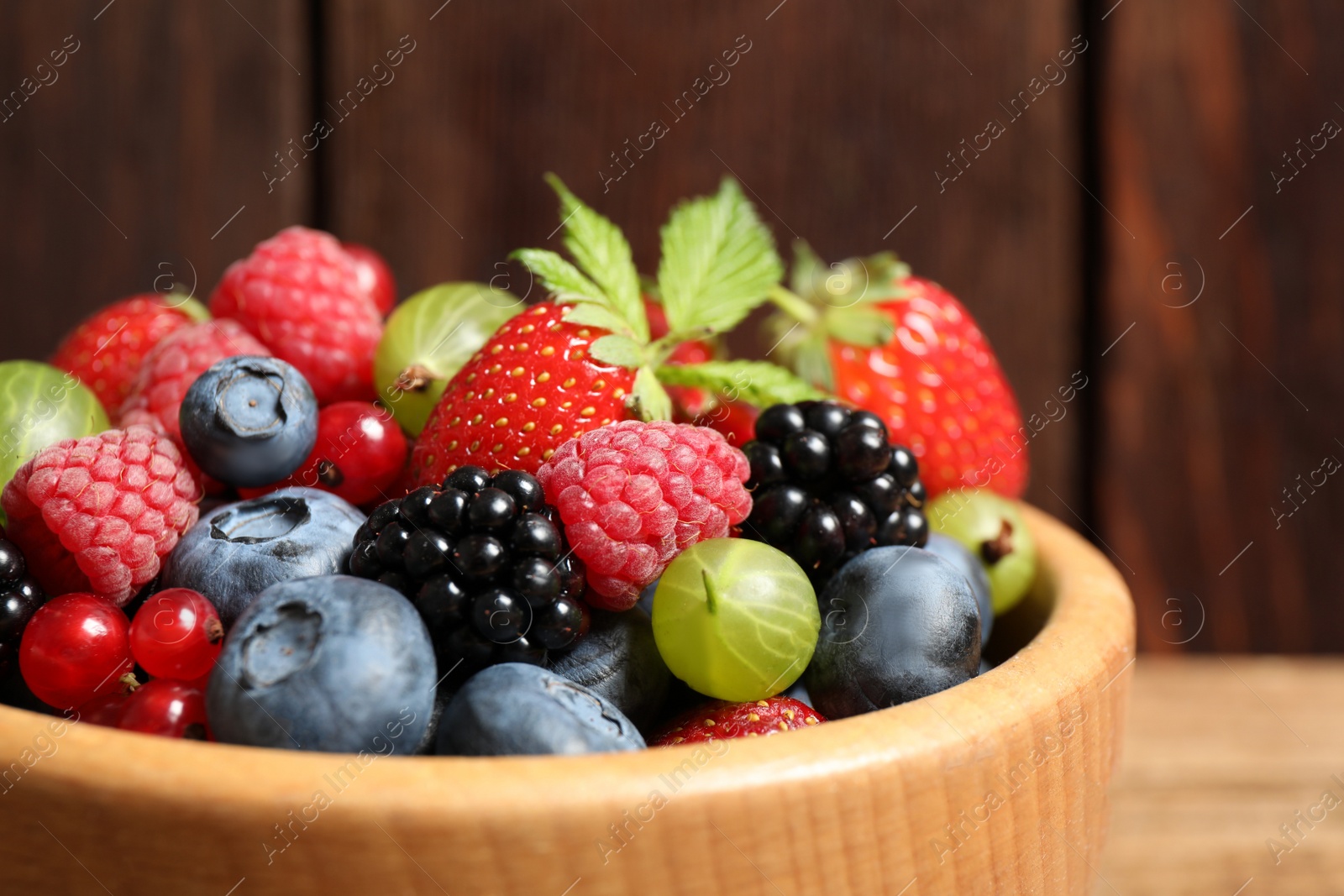 Photo of Mix of ripe berries in bowl, closeup