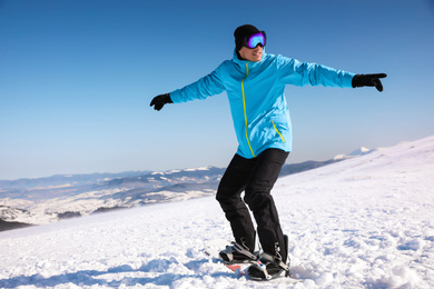 Photo of Man snowboarding on snowy hill. Winter vacation