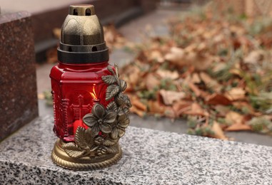 Photo of Grave lantern on granite surface at cemetery, space for text