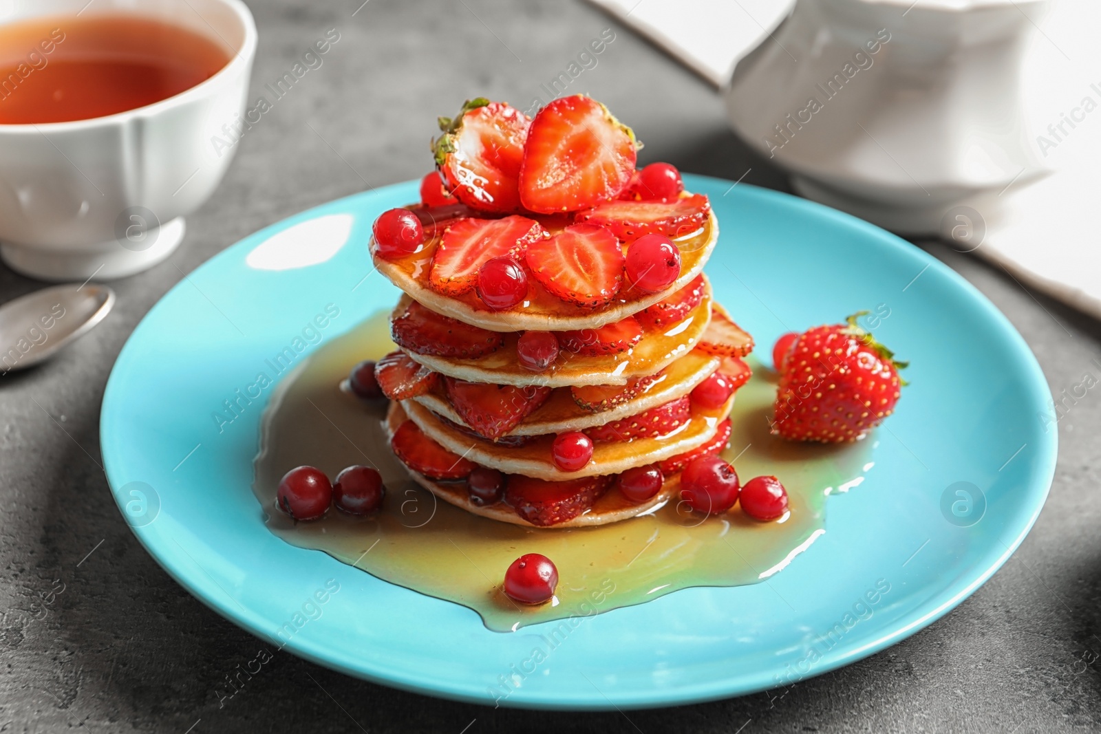 Photo of Tasty pancakes with berries and honey on plate