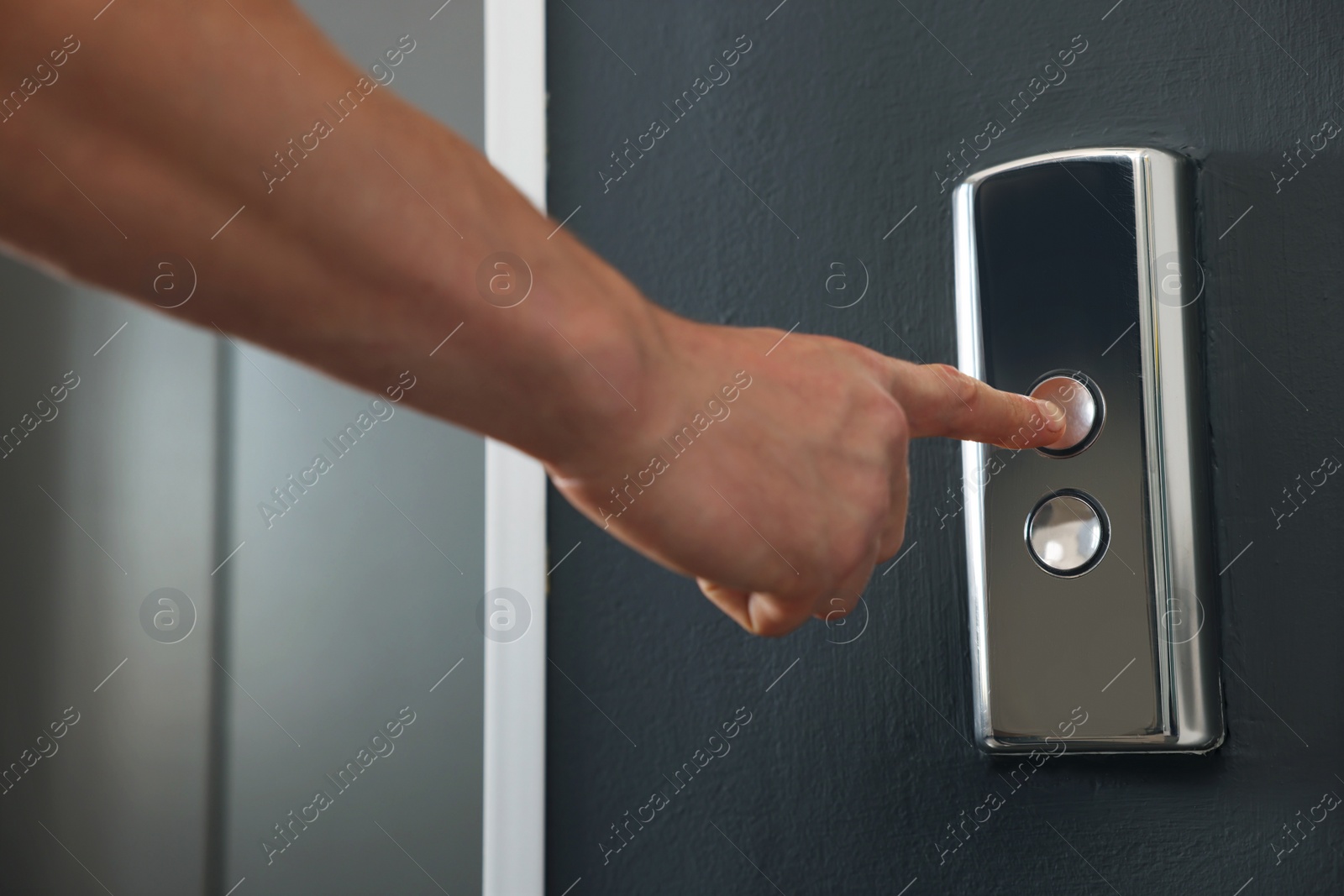 Photo of Man pressing elevator call button, closeup view