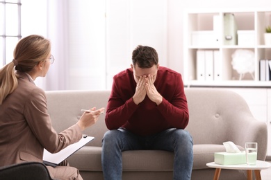 Psychotherapist working with young man in office