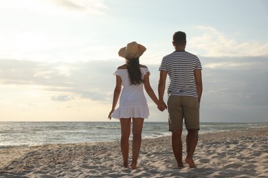 Lovely couple spending time together on beach, back view