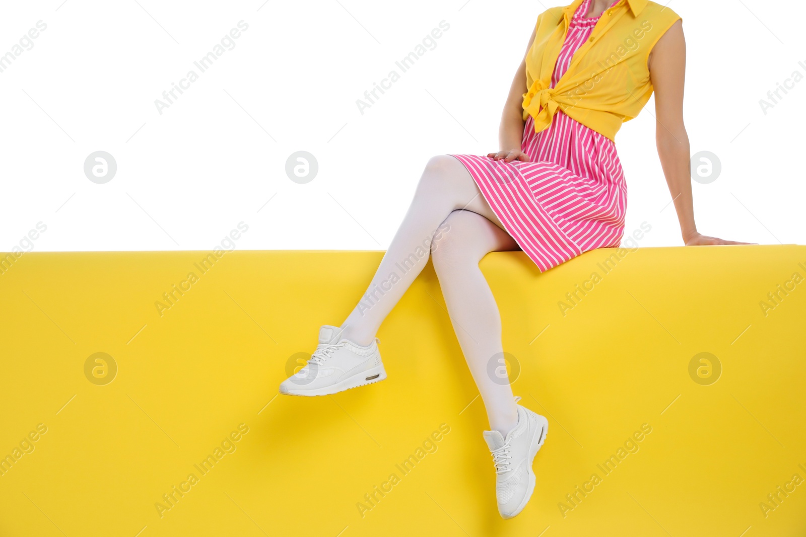 Photo of Woman wearing white tights sitting on color background, closeup. Space for text