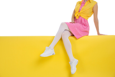 Woman wearing white tights sitting on color background, closeup. Space for text