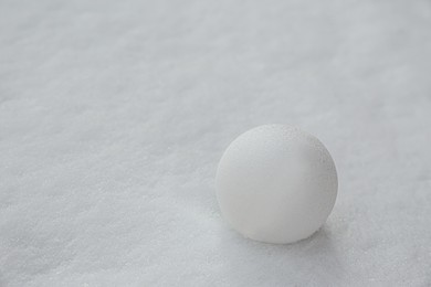 Photo of Perfect snowball on snow outdoors, closeup. Space for text