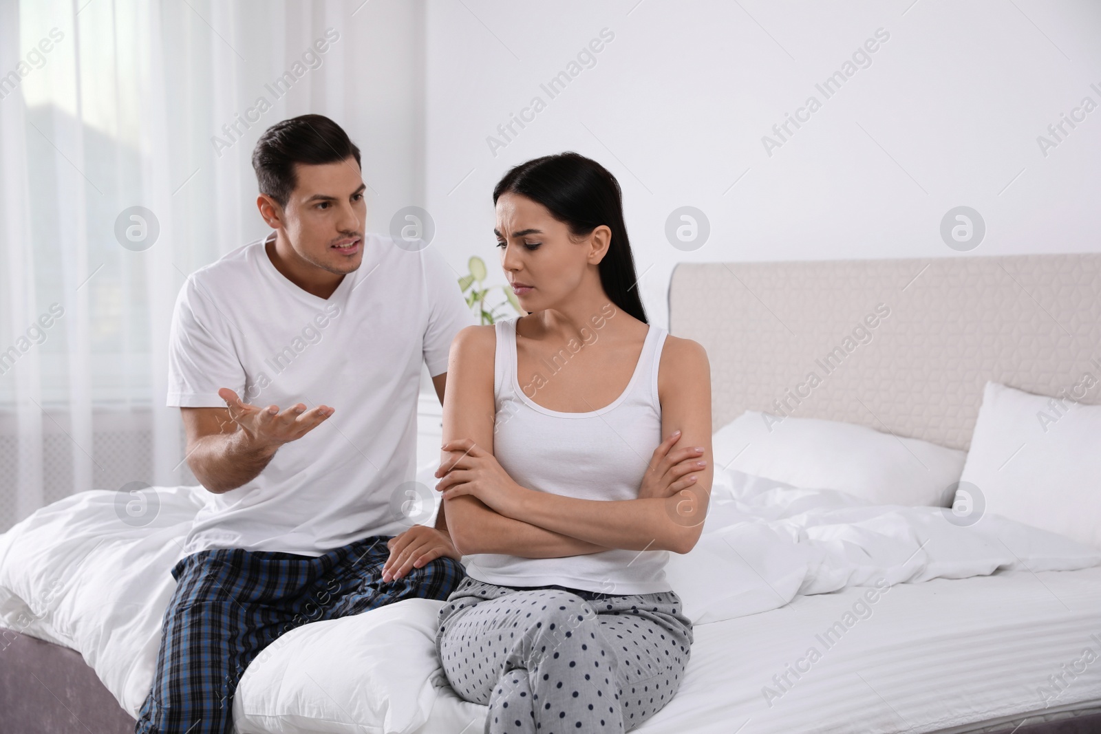 Photo of Couple with relationship problems quarreling in bedroom