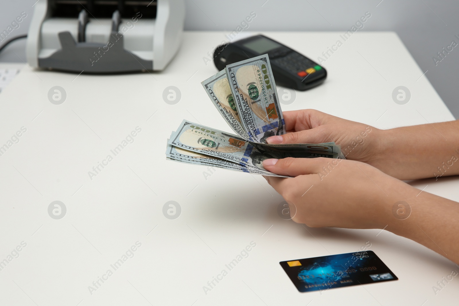 Photo of Woman with money and credit card at table, closeup
