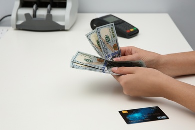 Woman with money and credit card at table, closeup