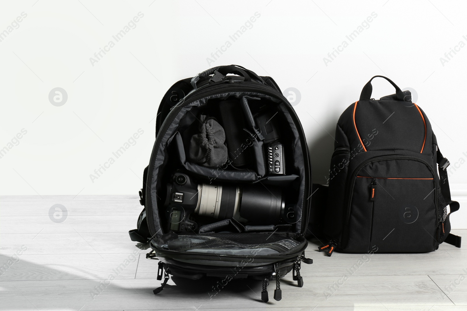 Photo of Backpacks with professional photographer's equipment on floor indoors
