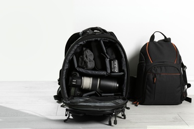 Backpacks with professional photographer's equipment on floor indoors