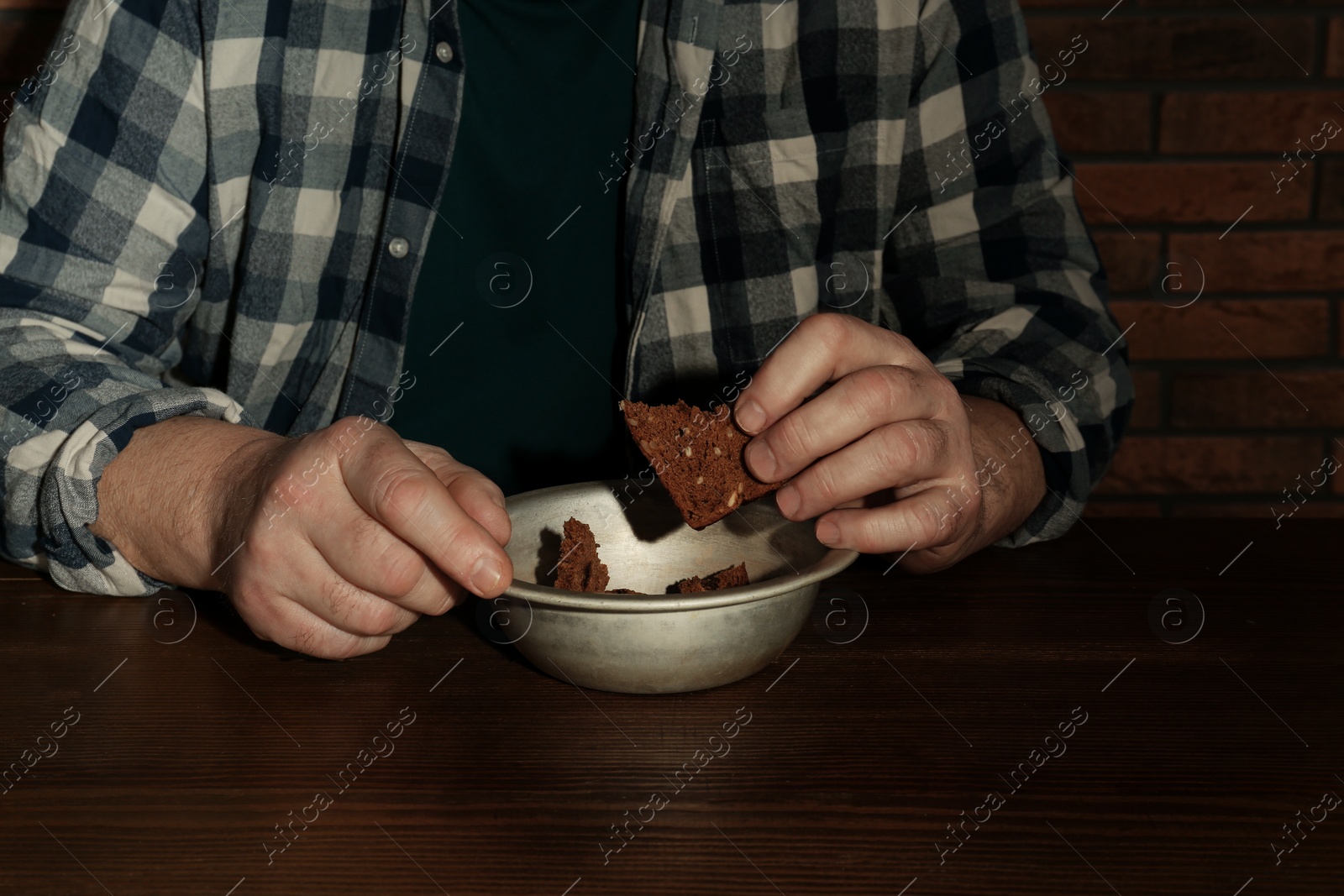 Photo of Poor senior man eating bread at table, closeup