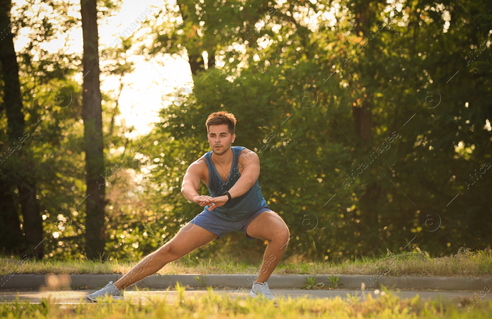 Photo of Young man doing exercise in park on sunny day