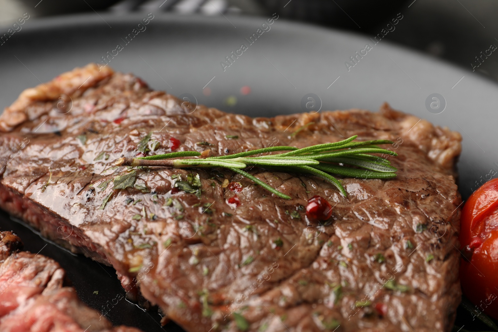 Photo of Delicious grilled beef steak with spices on plate, closeup