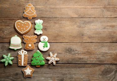 Christmas tree shape made of delicious gingerbread cookies on wooden table, flat lay. Space for text