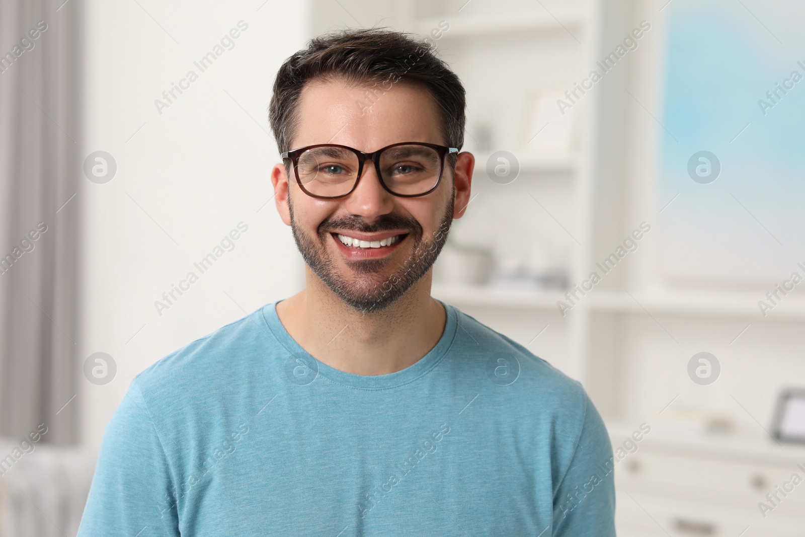 Photo of Portrait of happy man in stylish glasses at home