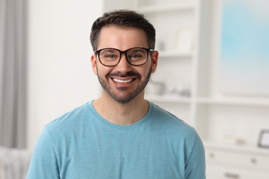 Photo of Portrait of happy man in stylish glasses at home