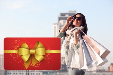 Store gift card. Happy woman with shopping bags outdoors