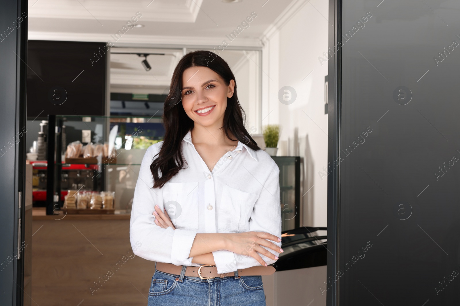 Photo of Happy business owner at door of her cafe