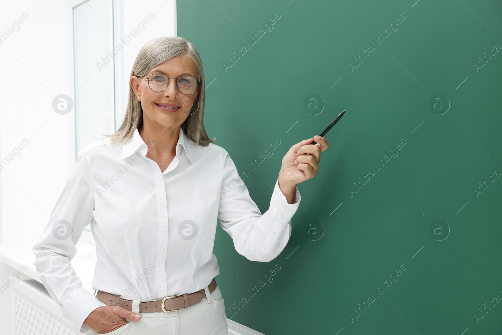 Photo of Professor explaining something at blackboard in classroom, space for text