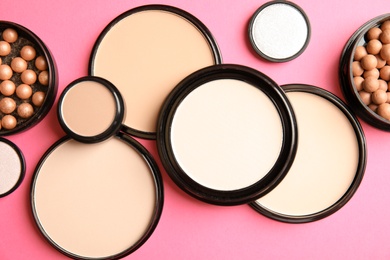 Photo of Flat lay composition with various makeup face powders on color background