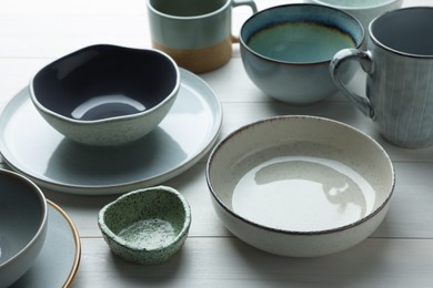 Stylish empty dishware on white wooden table, closeup