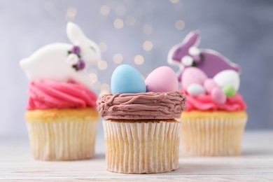 Photo of Tasty decorated Easter cupcakes on wooden table