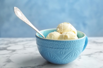 Cup with tasty vanilla ice cream on light table