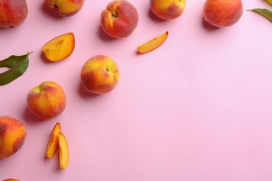 Flat lay composition with fresh peaches on pink background. Space for text