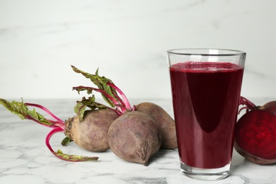 Photo of Freshly made beet juice on white marble table