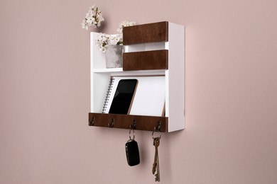 Wooden hanger for keys with different stuff on color wall