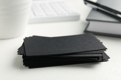 Blank black business cards on white table, closeup. Mockup for design