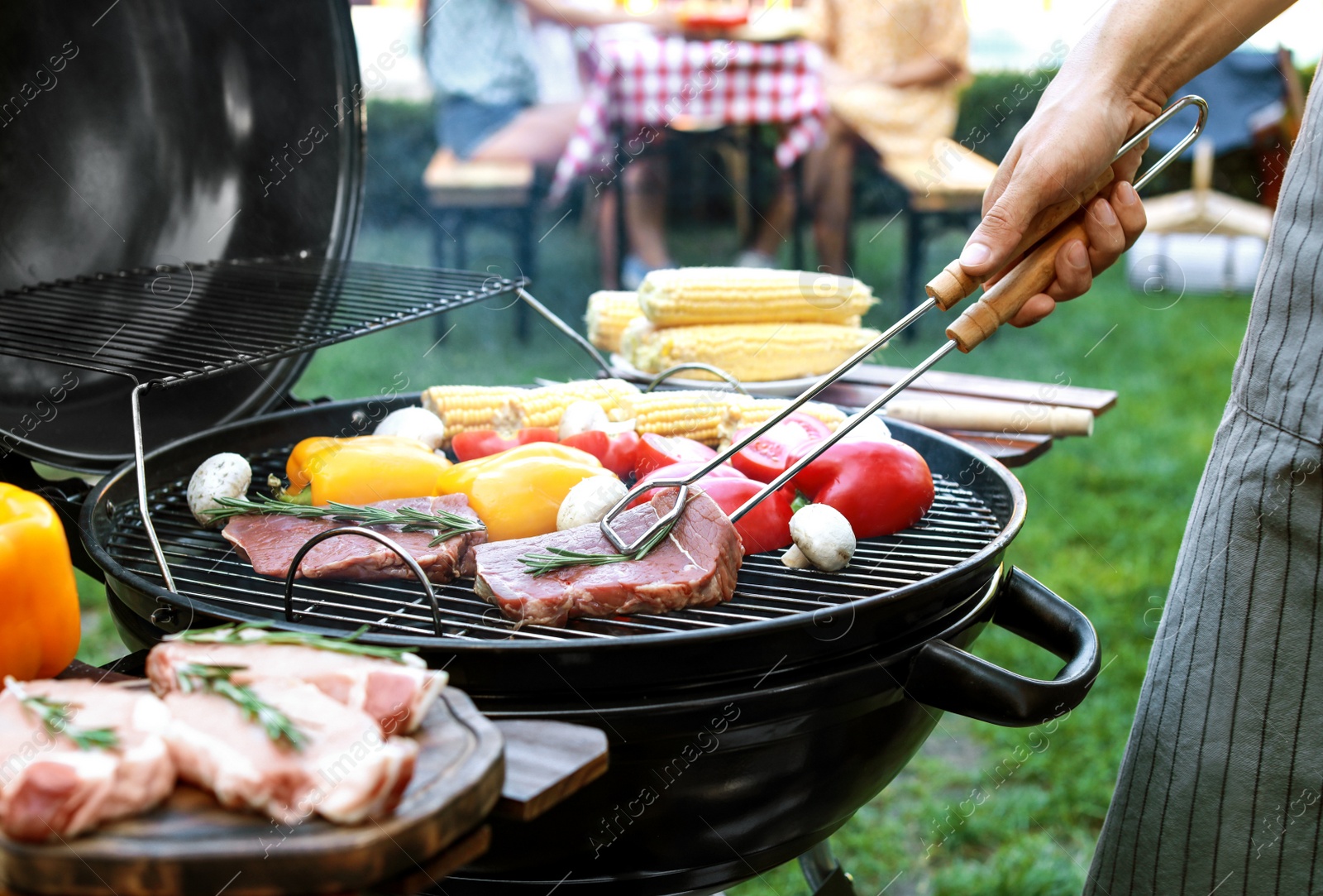 Photo of Man cooking on barbecue grill outdoors, closeup