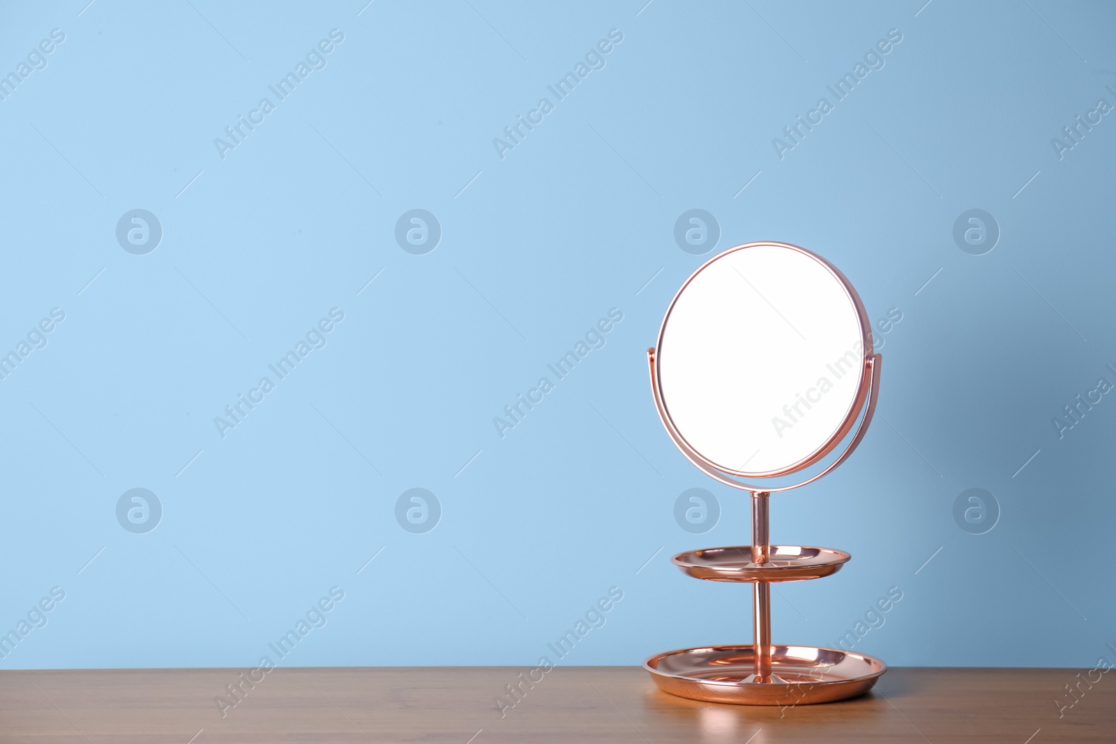 Photo of Mirror with accessory holder on table near color wall