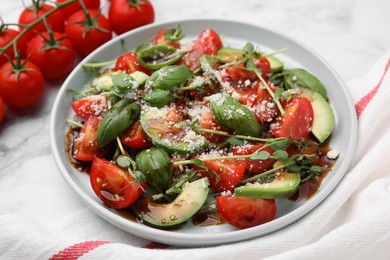 Photo of Tasty salad with balsamic vinegar on white marble table