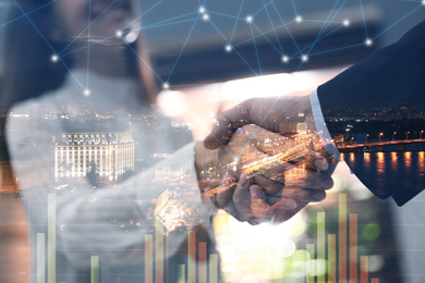 Image of Business people shaking hands and night cityscape, closeup. Double exposure