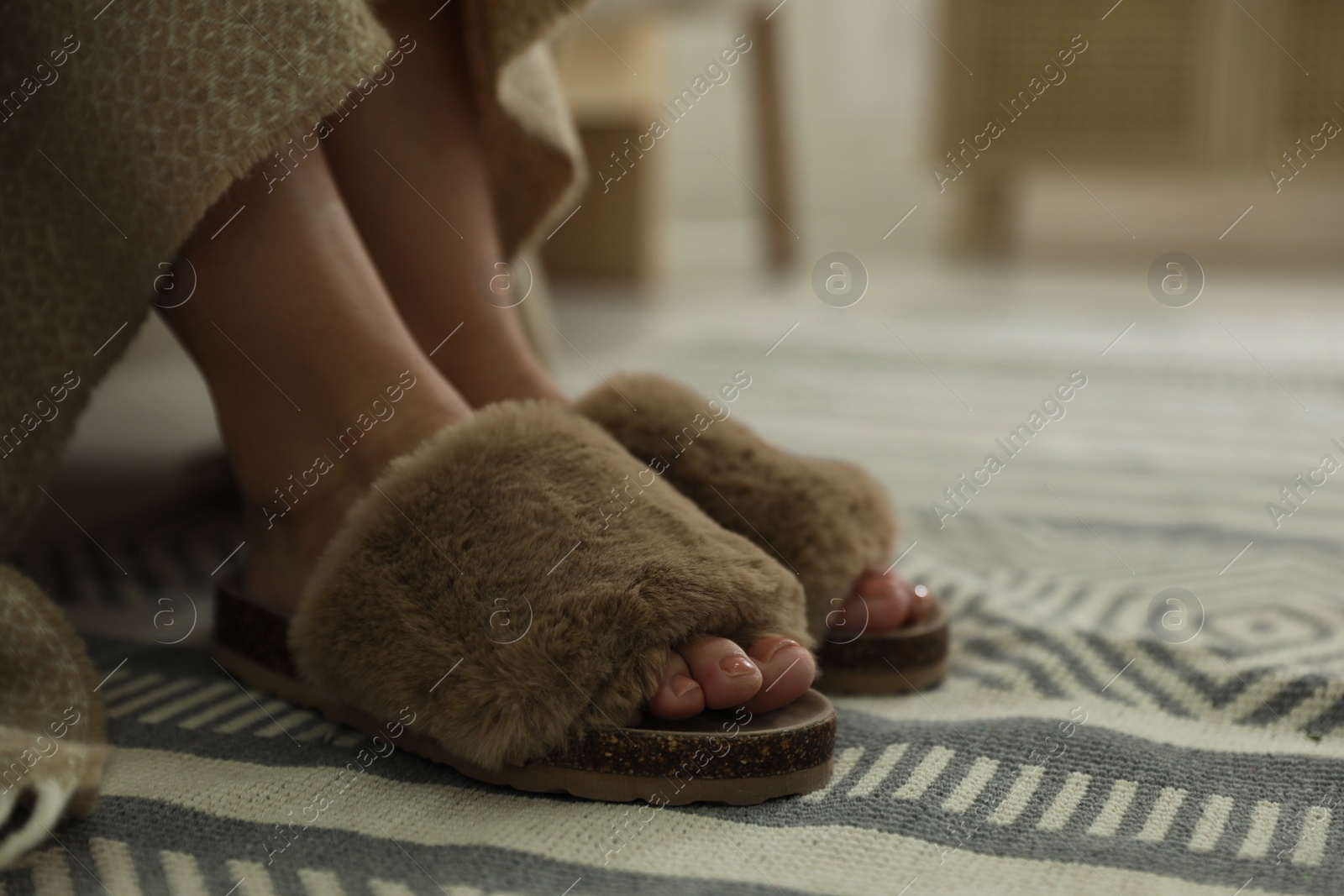 Photo of Woman with fluffy slippers in bedroom, closeup