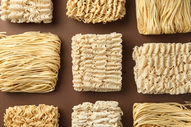 Photo of Flat lay composition with different quick cooking noodles on color background