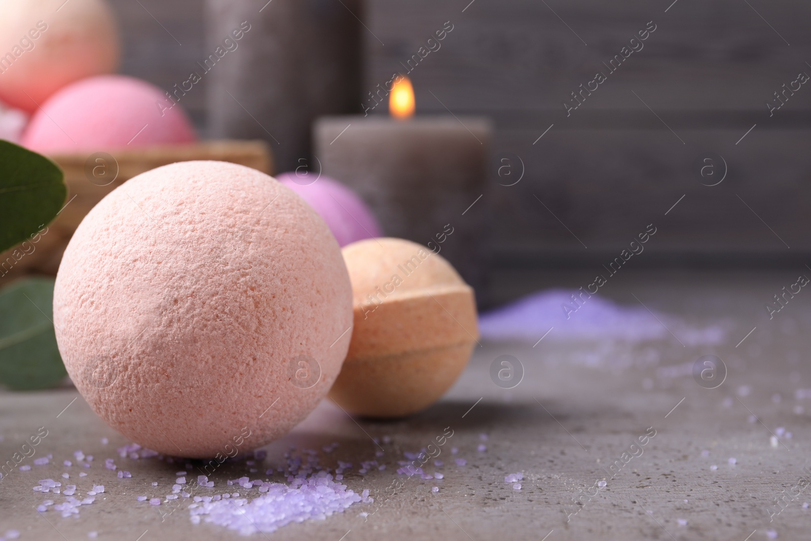 Photo of Beautiful aromatic bath bombs on grey table, closeup. Space for text