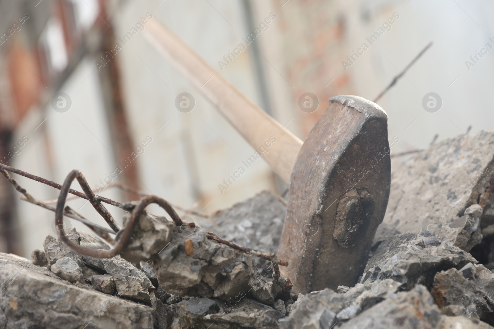 Photo of Sledgehammer on pile of broken stones outdoors, closeup